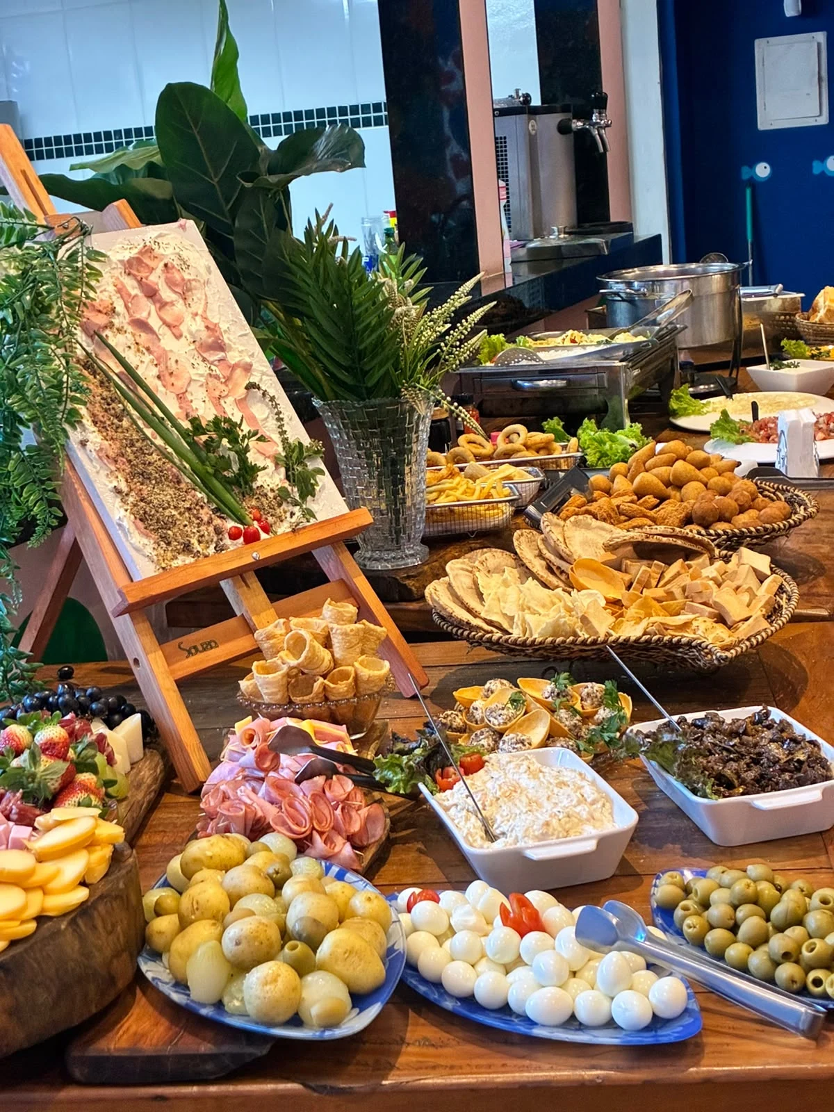 Mesa gastronômica com queijos, frios, salgados, frutas e acompanhamentos